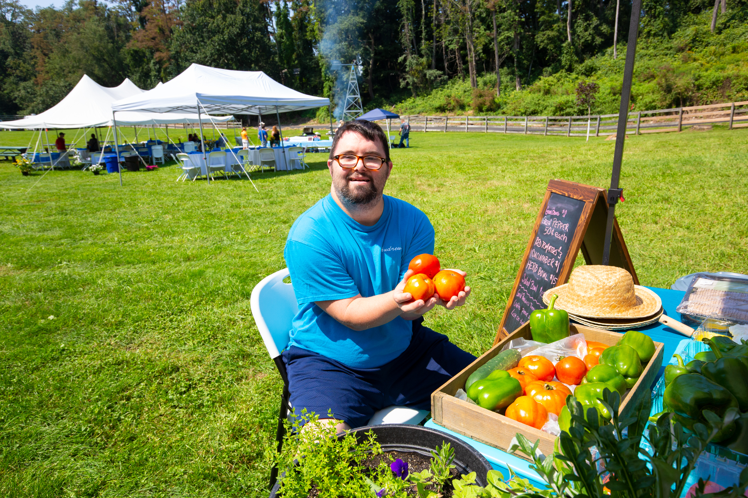 Man working at farmer's market holding tomatoes