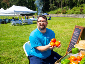 Man holding tomatoes at Cultivating Dreams Farm