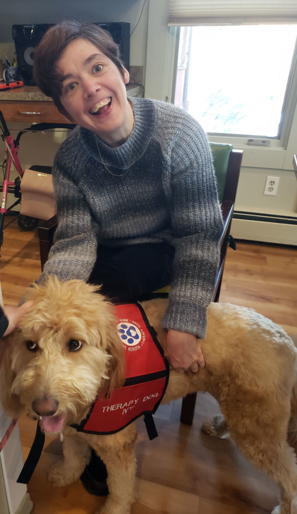 Resident in a Community Based Services home pets a therapy dog