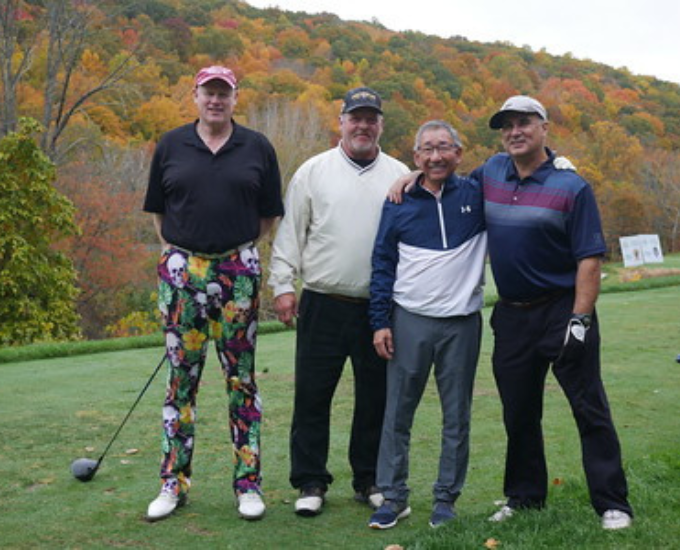 Four golf players for Canon Solutions America stand side by side on the Hollow Brook Golf Course.