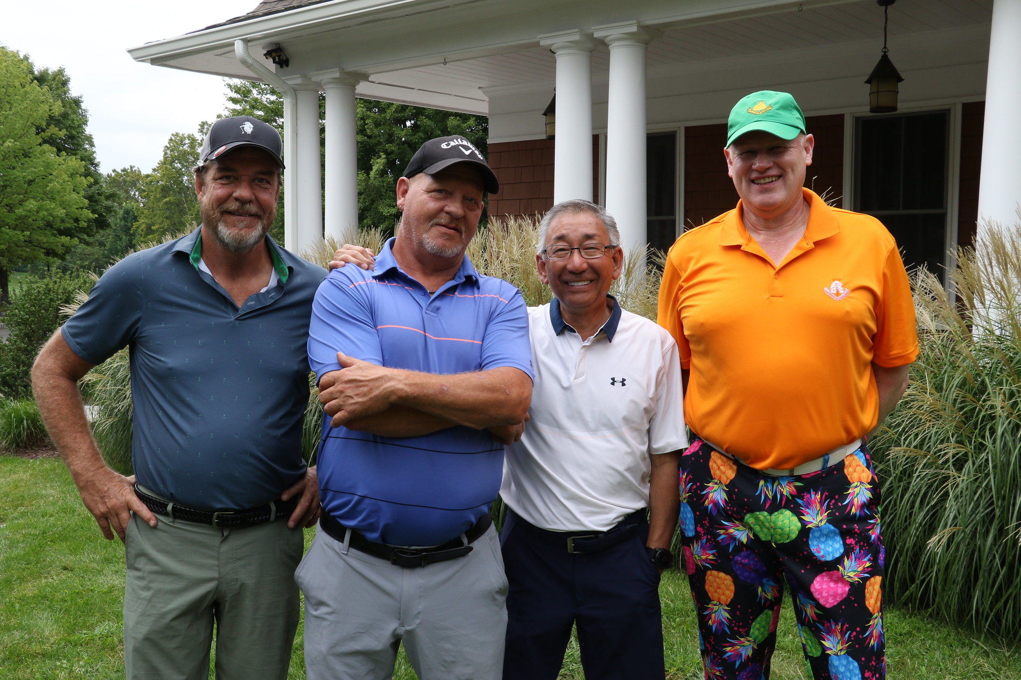 Four men in golf attire stand outside the club house at Hollow Brook Golf Club during the Community Based Services' charity golf event.