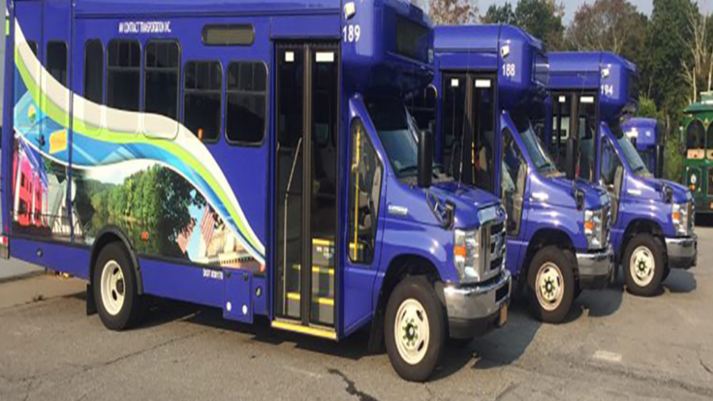 3 blue paratransit vans with splashy graphics parked in Putnam County NY