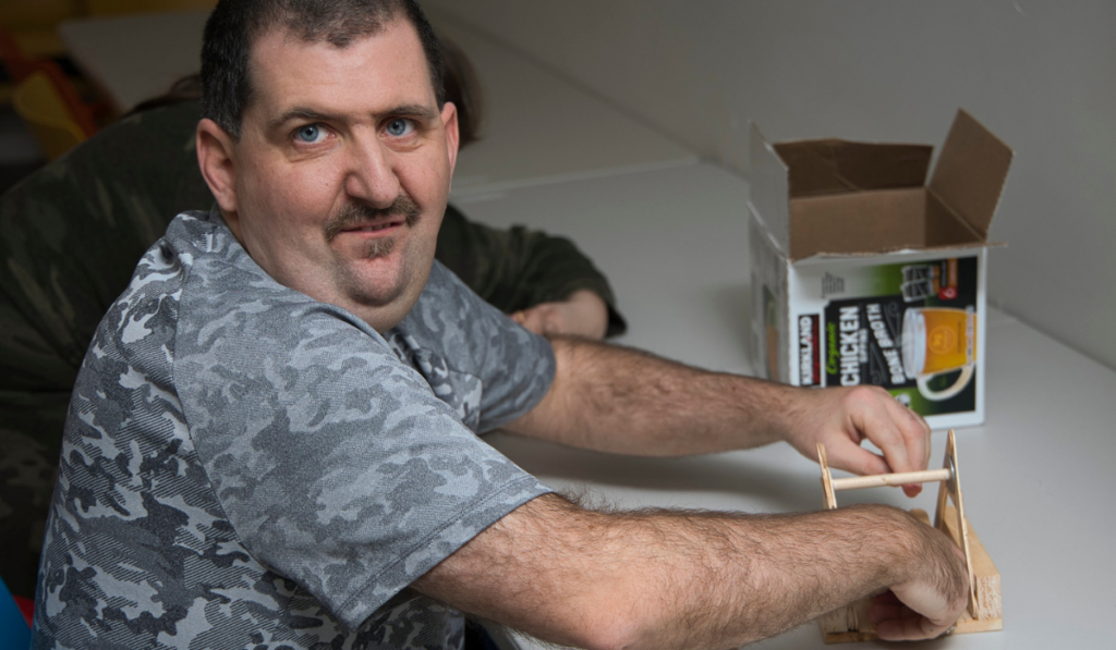 A man works on an engineering project in STEAM class.