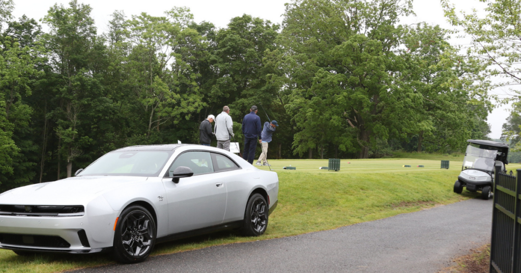 Golf players try to sink a hole in one to win a Dodge Charger car.