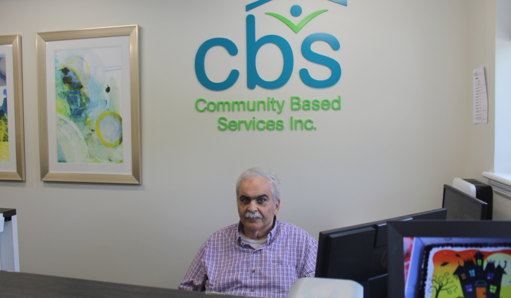 John B sits at his receptionist station.