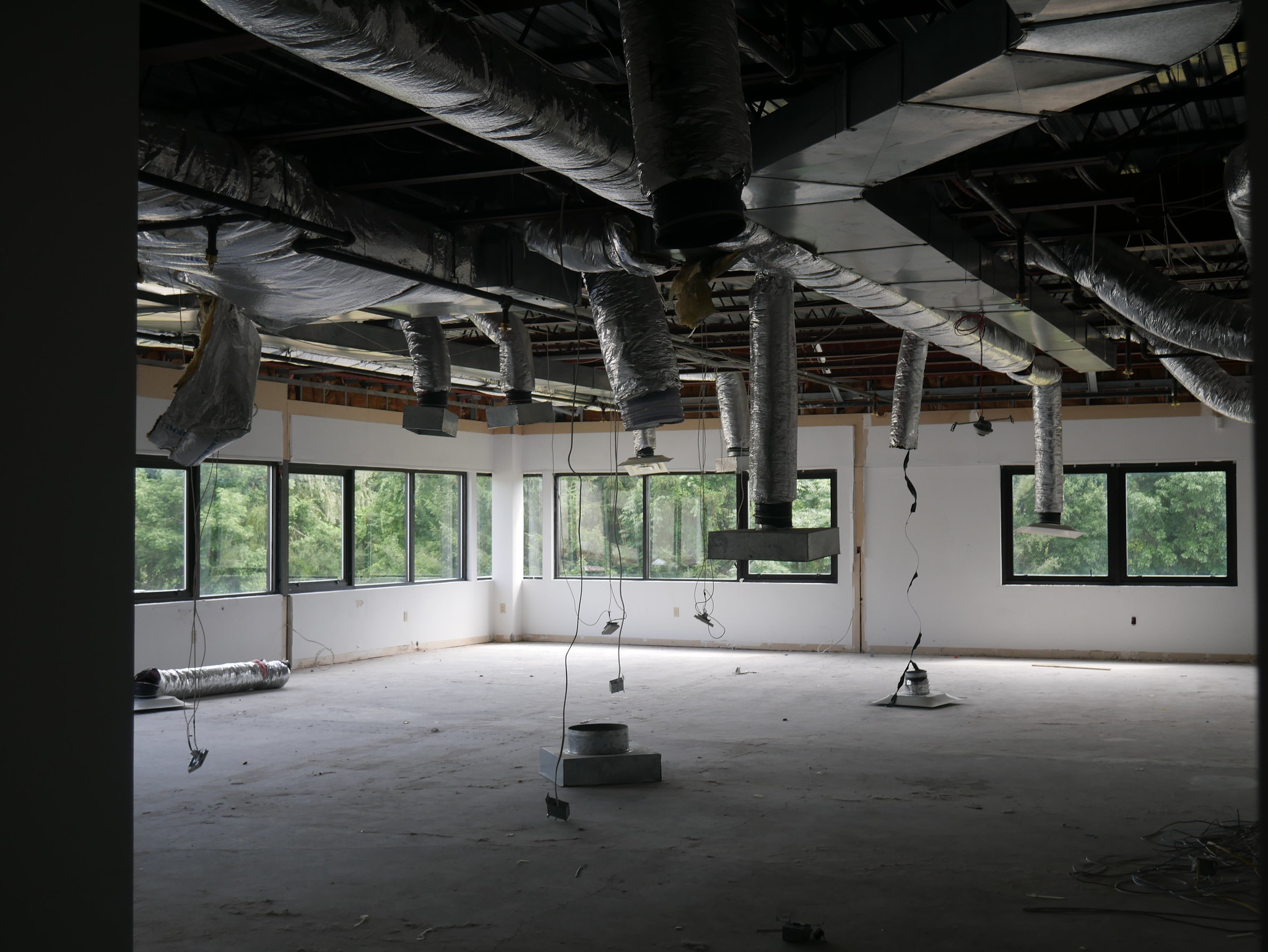 Construction begins inside 40 Jon Barrett Road in Patterson, NY. This interior photo shows an exposed ceiling and ductwork, and concrete floors.