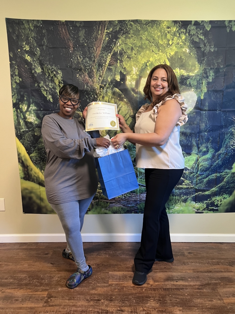 Nominee Dorthelea Williams receives her certificate and Gift from her manager.