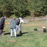 A group waits in line for a turn to play a ball toss game.