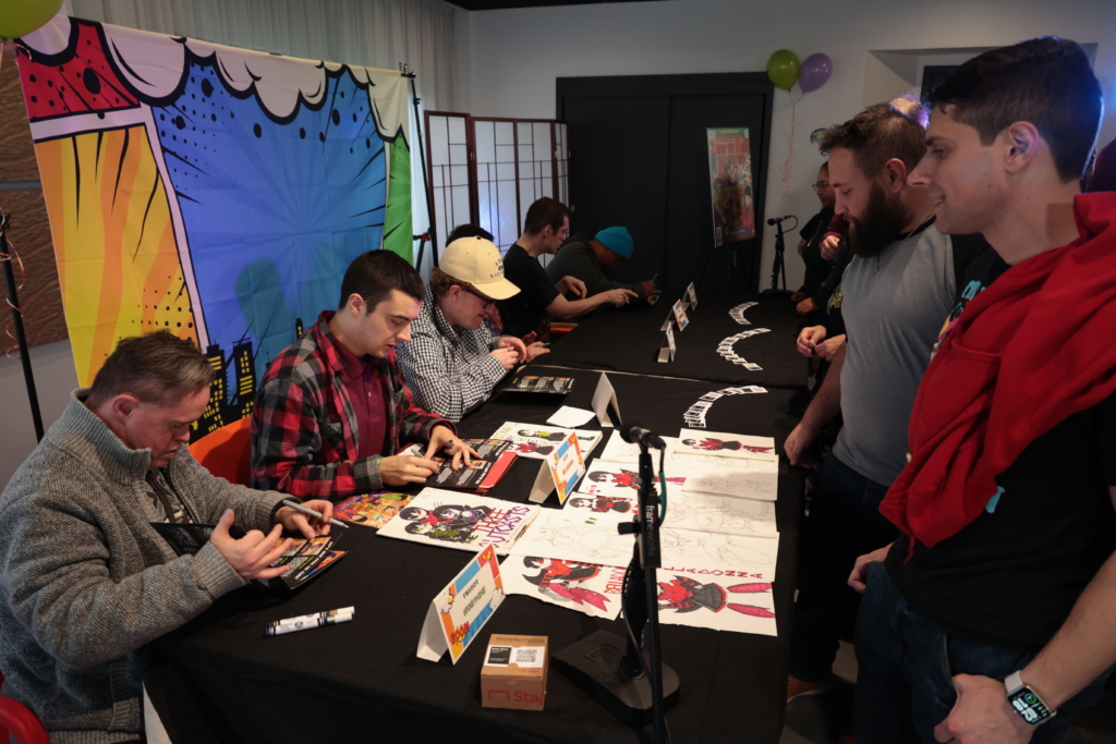 Fans line up to have their comic books signed by the creators of Zero to Hero