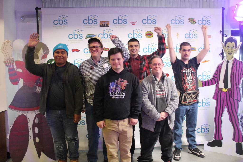 The creators of the Zero to Hero comic book stand as a group flanked by full size cutouts of the characters.