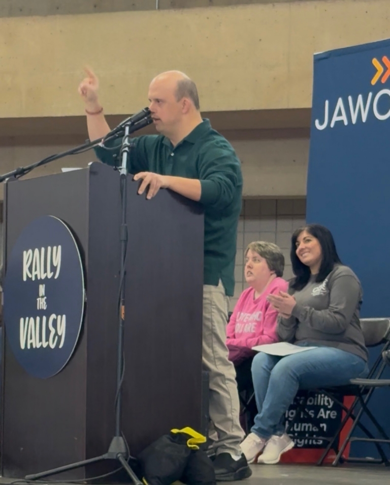 Brandon T. stands at a podium and speaks into the microphone at Rally in the Valley 2026.