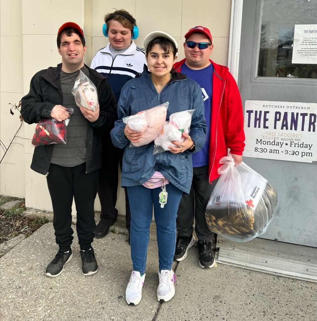 A CBS Day Hab group waits outside the food pantry entrance of the Dutchess Outreach, arms loaded with stuffed animals to donate.