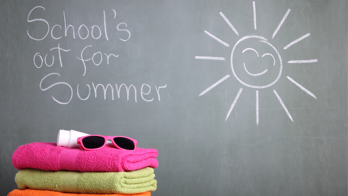 Orange, yellow and pink beach towels are folded and placed on top of each other with a pair of sunglasses placed on top of the pile. Behind them is a black board with chalk writing that says, "School's out for summer." A large sun symbol is drawn on the right side of the board.