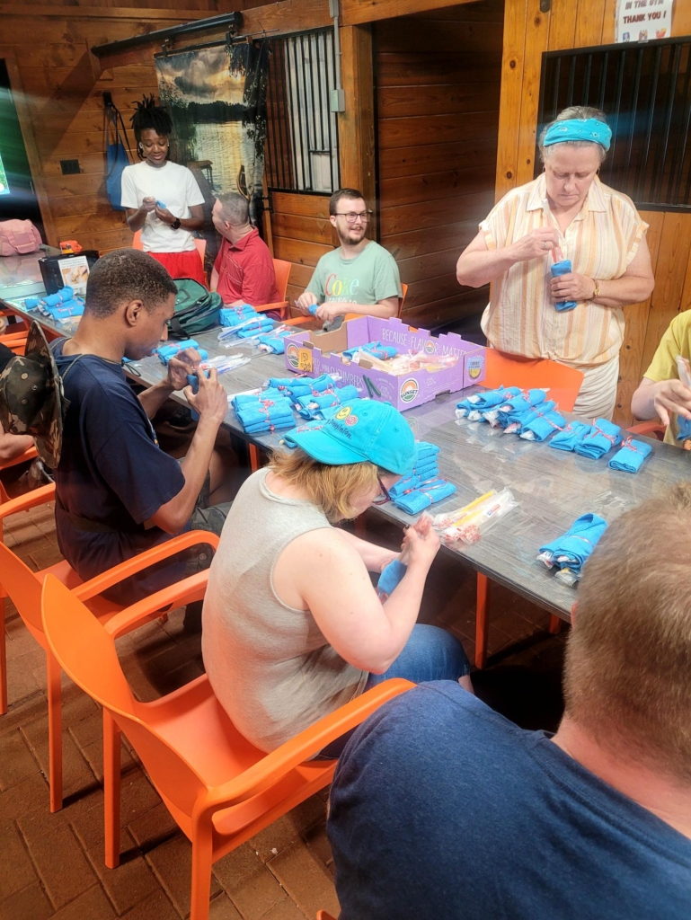 The CBS group day hab works on their 9/11 project of packing bags in the barn on a long table.