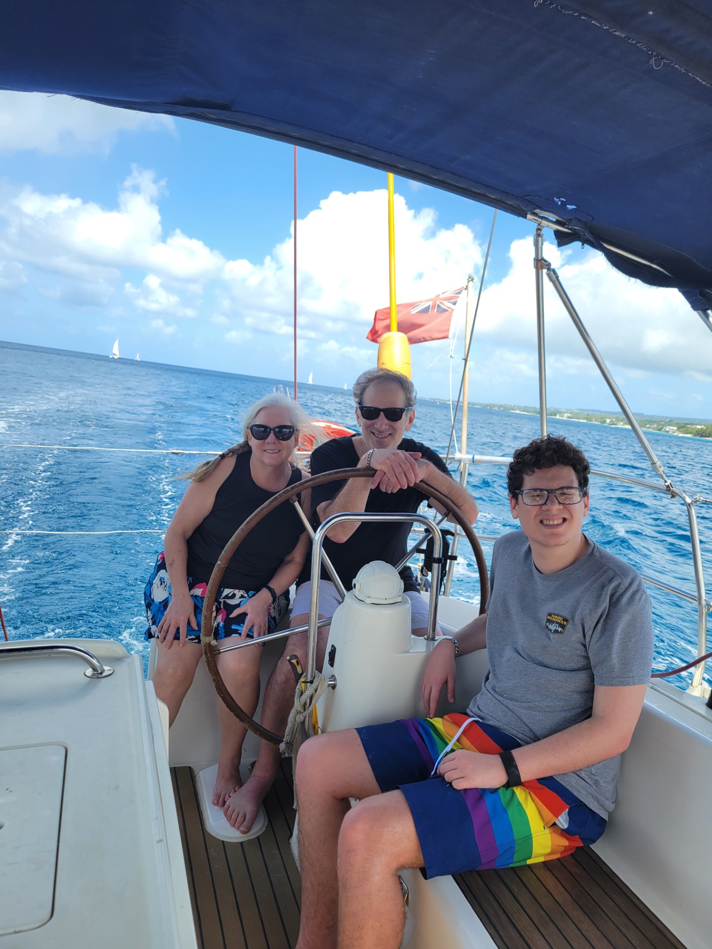 A mother, father, and son smiling together while enjoying time on a boat.
