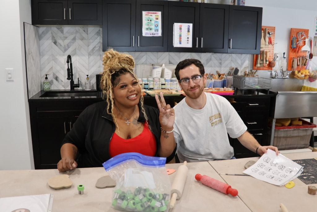 Two DSPs have fun working with clay while sitting at a table in the InterArts ceramic studio.