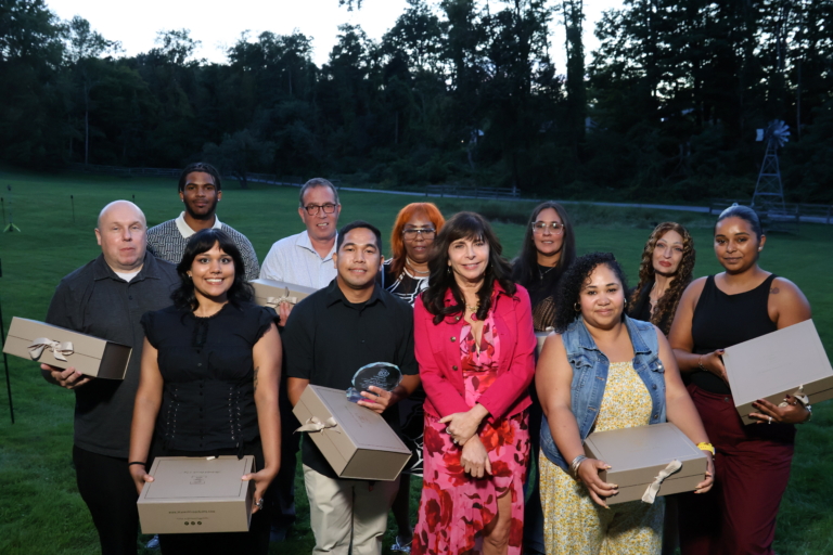 Nominees for CBS Employee of the year gather with CEO Vicki M. Sylvester, PhD at Cultivating Dreams farm for the awards ceremony. The nominees hold gift boxes.