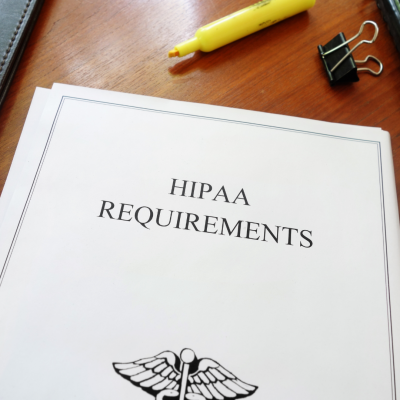 A folder marked HIPAA Requirements on a desk with a highlighter pen